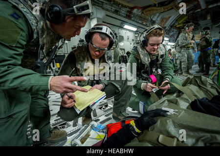 Von links, taktische Intensivpflege expeditionary Team – verbesserte (TCCET-E) Mitglied der US Air Force Captain Richard Rogers, Krankenschwester Anästhesisten, 86. Medical Group, Ramstein Air Base, Deutschland und US Air Force major Corey Norton, Flug Krankenschwester, 43. Aeromedical Evakuierung-Geschwader, Papst Army Airfield, N.C., Rekord Patienten Vitalfunktionen als Senior Airman Nichole Kilinc, flugmedizinischen Dienst Geselle, auch mit den 43. Riemen unten Schauspielpatienten während während des Fluges an Bord einer c-17 Globemaster III am Joint Readiness Training Center (JRTC) , Fort Polk, Louisiana, 18. Januar 2014. Service-Mitglieder am JRTC 14-03 sind e Stockfoto