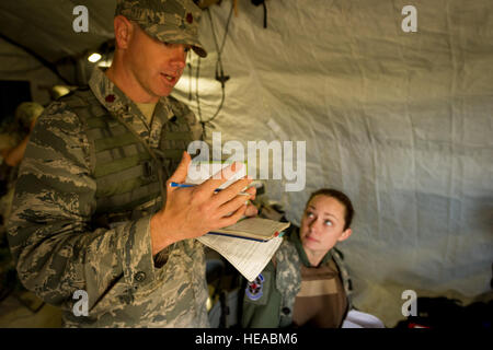 US Air Force major Corey Norton (links), Beobachter/Controller, Trainer, 43. Aeromedical Evakuierung-Geschwader, Papst Army Airfield, N.C., gibt Feedback zu einem aeromedical Evakuierung Besatzungsmitglieder während einem preflight Briefing am Joint Readiness Training Center, Fort Polk, Louisiana, 17. März 2014. Service-Mitglieder am JRTC 14-05 sind in Bekämpfung Patientenversorgung und aeromedical Evakuierung in einer simulierten Kampf Umgebung ausgebildet.  Master Sergeant John R. Nimmo, Sr. /) Stockfoto