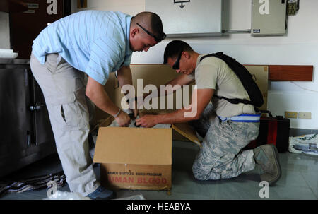 US Navy Petty Officer 1st Class John Gromer, ein Rettungssanitäter und US Air Force Tech SGT Terrence Wright, ein Luft-Transport-Handwerker Paket einen Kühler mit Einheiten des Blutes mit Eis am staging Zwischenboden Airfield Utapao Royal Thai Navy, Thailand, 10. Mai 2015. Das Blut war Teil einer Sendung Sendungen nach Kathmandu, Nepal, um die kontinuierliche Unterstützung der humanitären Hilfe und Katastrophenhilfe Hilfsmaßnahmen zu unterstützen. Nach dem Erdbeben der Stärke 7,8, die die Nation 25 April geschlagen, das US-Militär geschickt Flieger, Marines, Soldaten und Matrosen ein Stockfoto