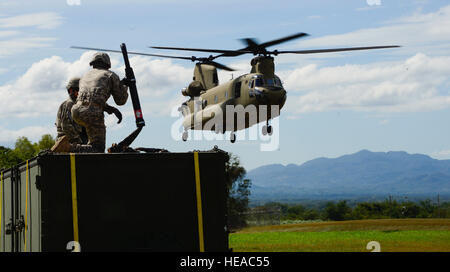 Bereiten Sie US Army Schutzzertifikate Jack Holz und David Swain, zum der Armee Truppen Bataillon, zugewiesen ein CH-47 Chinook während Luft Last und Fly-away Ausbildung auf Soto Cano Air Base, Honduras, 25. November 2014 einen Container zuordnen. Die Ladung wurde an die U. S. Befehl situative Bewertungsteam Süd an der Krieger-Rampe für die Beschäftigung in der heutigen Fortbildungsveranstaltung ausgeliefert.  Während der Ausbildung Mitglieder des S-SAT empfangene Ausbildung zum Einrichten einer Pre-Positioned Expeditionary Hilfe Kit zur Vorbereitung des Teams reagieren effizient auf humanitäre Hilfe und Katastrophenschutz Antwort-Situationen in U Stockfoto