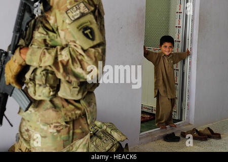 Ein afghanischer Junge Uhren Mitglieder der Kandahar Provincial Reconstruction Team bieten optimale Sicherheit für einen Schlüssel Führer Engagement zwischen afghanischen Funktionäre und Mitglieder des PRT, 5. Mai 2012, in Kandahar, Afghanistan. Kandahar PRT ist ein gemeinsames Team der US Air Force, Armee, Marine Service-Mitglieder und Zivilisten in der afghanischen Provinz Kandahar bereitgestellt, bei der der Aufwand für den Wiederaufbau und Stabilisierung der lokalen Regierung und Infrastruktur. Stockfoto