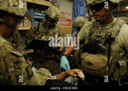 Mitglieder der Kandahar Provincial Reconstruction Team behandeln eine simulierte Kausalität während eines Bohrers Basisverteidigung 12. August 2012 in Kandahar, Afghanistan. Kandahar PRT ist ein gemeinsames Team der US Air Force, Armee, Marine Service-Mitglieder und Zivilisten in der afghanischen Provinz Kandahar bereitgestellt, bei der der Aufwand für den Wiederaufbau und Stabilisierung der lokalen Regierung und Infrastruktur. Stockfoto