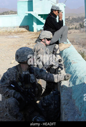 Massachusetts Army National Guard Sicherheitskräfte Mitglieder, Spc. Justin Duncan aus Port Huron, Michigan, und Spc. Matthew Flynn von Pelham, N.H., Mitglied der nationalen Polizei Afghanistan zu scannen und die Landschaft während ein Schlüssel Führer Engagement im Bezirk Jaji Maidan, Jan. 8. Die KLE bestand aus dem Distrikt-Governor und Führungskräfte aus Khowst Provincial Reconstruction Team.  US Air Force Tech Sergeant Matthew Lohr) Stockfoto