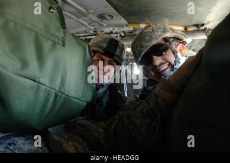 Kaplan (Capt) Kelvin Francis, 732. Air Expeditionary Gruppe religiöser Support-Team, derzeit im Einsatz von Shaw Air Force Base, SC, und 1st Lt. Lawrence Hufford 732. Expeditionary Bauingenieur-Geschwader, bereitgestellt von Minot AFB, N.D., Lächeln, als sie Spielzeug, Kleidung transportieren und zu Bagdad International Zone Schulsachen. Die Lieferungen mit einem Gewicht von mehr als 500 Pfund erfolgte durch die 732. AEG RST und eine Gruppe von Freiwilligen aus einer Servicemembers Organisation namens Kinder im Irak. Die Freiwilligen und Lieferungen wurden von Joint Base Balad, das IZ durch eine Armee, Aufgabe für transportiert Stockfoto