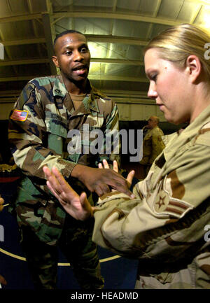 FORT LEWIS, Washington - Armee Sgt. 1. Klasse John Redmon (links) zeigt die Airman 1st Class Rachel Kindvall den richtigen Griff und Technik bei der Verteidigung gegen eine nach oben Messer Angriff während einem Häftling Operations training Klasse hier.  Beobachter-Controller wie Sergeant Redmon sind Soldaten mit operativer Erfahrung, Ausbildung Servicemembers auf wie sicher Pflege und Kontrolle inhaftierten mit der geringsten Menge an notwendigen Kraft gewidmet.  Airman Kindvall erhält die 55. Sicherheit Kräfte Squadron in Offutt Air Force Base in Nebraska   Techn. Sgt Larry A. Simmons) Stockfoto