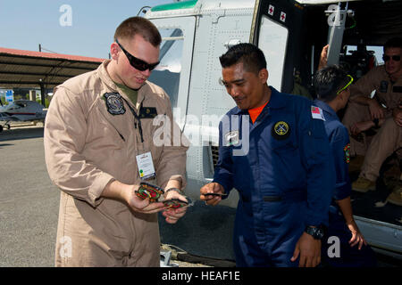 Marine Sgt. Jesse Williams, Marine Light Attack Helicopter Squadron 367 Flugwerken Mechaniker vom Marine Corps Base Hawaii, tauscht Einheit Flecken mit einem Mitglied der Royal Malaysian Navy auf der Flightline am internationalen Flughafen Langkawi, Malaysia, 17. März 2015. Williams ist mit UH-1Y Huey statische Anzeige bei der Langkawi International Maritime and Aerospace Exhibition 15. Teilnahme an der LIMA 15 Airshow zeigt die US Air Force Engagement für die Stärkung der Beziehungen mit Malaysia.  Techn. Sgt Terri Paden /) Stockfoto