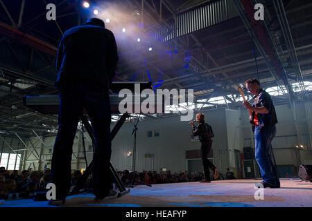 Bass-Gitarrist, Emmy, Golden Globe-prämierten Schauspieler Gary Sinise und Lt. Dan Band führen für US-Küste Gardisten in einem Hubschrauber Wartung Hangar 25. Juni 2012 bei Coast Guard Air Station Kodiak, Alaska. Sinise und Lt. Dan Band sind in Alaska auf einer drei-Stopp-Tour durchzuführen für militärischen Service-Mitglieder und ihre Familien die Lt. Dan Band zahlreiche Konzerte auf der ganzen Welt zu unterstützen, Mitglieder des US-Militär durchgeführt haben. Stockfoto