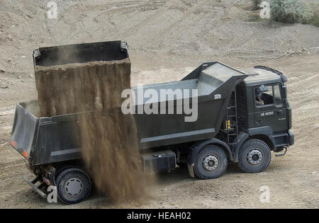 Ein polnischer Soldat in einem Erdbewegungsmaschinen Fahrzeug bewegt sich im Schmutz in einen LKW für eine Wand aus Barrieren um Viper Stadt auf Bagram Air Base, Afghanistan 7. Mai 2002 verwendet werden entladen. Diese Barrieren, hergestellt von der Firma Hesco werden verwendet, um den Schutz der Truppe für die hier stationierten Soldaten besser. Dies wurde zur Unterstützung der Operation Enduring Freedom.  Staff Sergeant Ricky A. Bloom) (veröffentlicht) Stockfoto