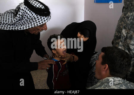 Ein US-Army 7th Special Forces Group Medic wirft einen Blick einen kleinen irakischen Jungen Mandeln in der Al Salam medizinische Klinik in Al Hayy, Irak, am 24. November 2008.   US Army 7th Special Forces Group und El salvadorianischen Sanitäter veranstaltet eine MEDREADY Behandlung von mehr als 200 Patienten.    Staff Sgt Rasheen A. Douglas Stockfoto