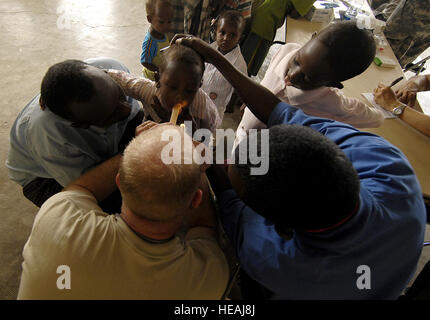 Medic Sgt. Aaron Parde 354. Civil Affairs (CA) Brigade, spezielle Funktionsweise Team kombiniert Joint Task Force - Horn von Afrika, prüft den Mund eines jungen Patienten während einer medizinischen zivilen Aktion Projekt (MEDCAP) am 29. März 2008 am Goubetto Dorf, Dschibuti. Die 354th führt eine sechs-Tage-MEDCAP rund um den Bereich Dschibuti mit ihren ersten zwei Tage im Goubetto Village sehen über 500 lokalen Djiboutian Patienten durch am Ende des Tages zwei. Stockfoto