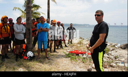 Sgt. 1. Klasse Tim Borton Hawaii Army National Guards CERFP Suche und Gewinnung Team bespricht Hydrologie mit Mitgliedern der Stadtverwaltung Subic Bay, The Philippine Military und philippinischen Roten Kreuzes Glattstellung der Wasser-Rettung-Demonstration als Teil des Balikatan 2013, 13. April 2013, Subic Bay Philippinen. Hawaii Army National Guard Such- und Experten sind die Fähigkeiten ihrer philippinischen counter Teile als Teil des Balikatan erfrischend. (TSgt Andrew Jackson) Stockfoto