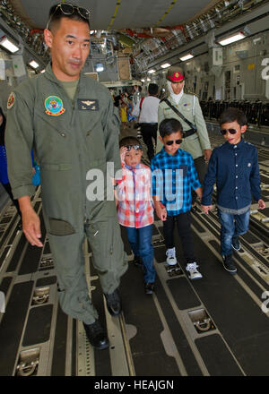 US Marine Corps Oberstleutnant Joseph Lee von der Marine Medium Tiltrotor Squadron 262, bietet eine Führung für Kinder des Königshauses Brunei an Bord einer c-17 Globemaster III statische Anzeige auf der Flightline auf Rimba Air Base während der 4. Biennale von Brunei Darussalam Verteidigung Weltausstellung, 4. Dezember 2013. Gemeinsame Basis Pearl Harbor-Hickam Personal sind die c-17 Globemaster III durch statische Displays und Luftaufnahmen Demonstrationen während BRIDEX präsentiert.  BRIDEX 13 ist eine Gelegenheit für networking und sharing-Technologie mit regionalen Partnern und Verbündeten, die starke multilaterale r baut Stockfoto