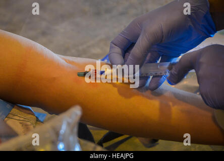 Capt Laura Yaris, ein Mitglied des chirurgischen Teams den Mobile, beginnt eine intravenöse Spritze auf einem simulierten Patienten während eines medizinischen Trainings auf der Al Udeid Air Base, Katar, 27. Februar 2014, an lebensrettenden Fähigkeiten zur Verwundeten Krieger arbeiten. Ein MFST ist eine Gruppe von Medizinern, die vorwärts Operationen des US Central Command Gebiet der Verantwortung und der Operation Enduring Freedom durch voraus Trauma Life Support und Intensivpflege für Service-Mitglieder, die im Kampf verwundet zu unterstützen. Mobile Einsatzteams chirurgische handeln als einen Übergangspunkt Patienten erreicht man die nächste Stufe der Auto Stockfoto