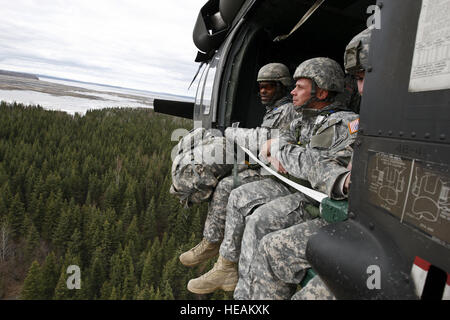 Sgt. 1. Klasse Jeremy Aquaowo (links) und Staff Sgt Andrew Wolfe (Mitte), beide von Headquarters und Headquarters Company, 1. Bataillon, 507. Parachute Infantry Regiment (U.S. Army Pathfinder School), Fort Benning, Georgia, nehmen in der Alaskan Ansichten, wie sie sich vorbereiten, mit dem Fallschirm aus einem UH-60 Black Hawk Hubschrauber auf Malamute Drop-Zone, 23. Mai 2013. Stockfoto