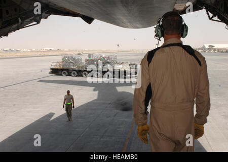 Master Sergeant Matthew Harr, 709th Airlift Squadron, beobachtet, wie Flieger vom 451st Expeditionary Logistik Bereitschaft Squadron Antenne Anschluss Flug Versorgungsgüter und Ausrüstungsgegenstände aus einer C - 5 M Super Galaxy Airfield Kandahar, Afghanistan, 19. September 2013 verschieben. Flieger aus dem 451st ELRS Antenne Anschluss Flug be- und Entladen von Fracht von militärischen und zivilen Flugzeugen U.S. liefern und Koalitionstruppen in Afghanistan. Harr ist ein von der Air Force Reserve Command 512th Airlift Wing auf der Dover Air Force Base, Delaware (US Air Force Fotostory / Senior Airman Jack Sanders) Stockfoto