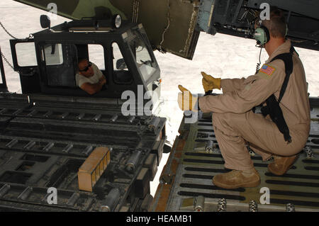 Master Sergeant Matthew Harr, hilft 709th Airlift Squadron ein Flieger vom 451st Expeditionary Logistik Bereitschaft Squadron Antenne Anschluss Flug, Lieferungen zu entladen und Ausrüstung aus einer C - 5 M Super Galaxy in Kandahar Flugplatz, Afghanistan, 19. September 2013 zu positionieren. Wie NATO-Truppen aus Afghanistan retrograde vorbereiten, hat der 451st ELRS Antenne Anschluss Flug Operationen, Engpässe in bewegten Ladung aus Afghanistan zu verhindern hochgefahren. Harr ist ein von der Air Force Reserve Command 512th Airlift Wing auf der Dover Air Force Base, Delaware (US Air Force Fotostory / Senior Airman Jack Sanders) Stockfoto