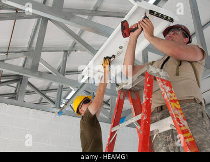 US Marine Corps Lance Cpl. Wesley Krueger, Marine Wing Support Squadron 473, links, US Army Spc. Thomas Warnsignal Ingenieur bereitgestellt von der Louisiana National Guard 1023rd vertikale Ingenieur Firma 528th Engineer Battalion, sichern eine Leuchte auf der Baustelle Edward P. Yorke 23. April 2014, in Belize City, Belize. BDF und US-Militärangehörige arbeiten zusammen, um neue Horizonte Belize 2014 fünf Schulgebäude und eine medizinische Einrichtung in ganz Belize zu bauen. New Horizons ist eine jährliche Veranstaltung koordiniert zwischen den USA und dem Gastgeberland, gegenseitige auszubilden Stockfoto