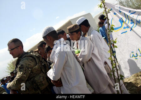 US Army 1st Lt. Cody Waters von Nangarhar Agribusiness Entwicklungsteam zusammen mit Studenten aus dem Rodat Bezirksgebiet beteiligt sich an Feierlichkeiten anlässlich der Eröffnung der lokalen Landwirtschaft-High-School. Gewässern ein Ingenieur mit der Nangarhar ADT V, 4th Brigade Combat Team, 4. US-Infanteriedivision war maßgeblich in der Leitung der Regierung der islamischen Republik Afghanistan Aktivitäten während der Planung und Bau dieses Projektes. Mitglied des Missouri Army National Guard Gewässern ein Jahr unermüdlichen Einsatz zur Unterstützung der infrastrukturellen Kapazitäten weiter gewidmet Stockfoto