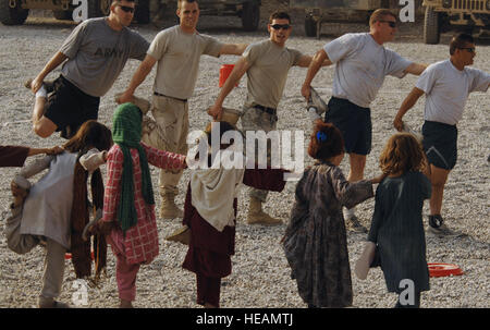 Armee und Luftwaffe Mitglieder von Nangarhar Provincial Reconstruction Team und Kinder aus der Gemeinde dehnen, bevor sie Fußball bei der PRT zusammenspielen vorwärts operative Basis in Jalalabad, 9. November 2007. Nangarhar PRT ist ein gemeinsames Team der Flieger, Soldaten und Vertretern der US-Abteilung von Staat, US Agency for International Development und das US-Landwirtschaftsministerium. Das Team ist verantwortlich für die Unterstützung der Regierung der islamischen Republik Afghanistan verbessern Sicherheit, Governance und Wiederaufbau in der Provinz Nangarhar. Die PRT bewertet co Stockfoto