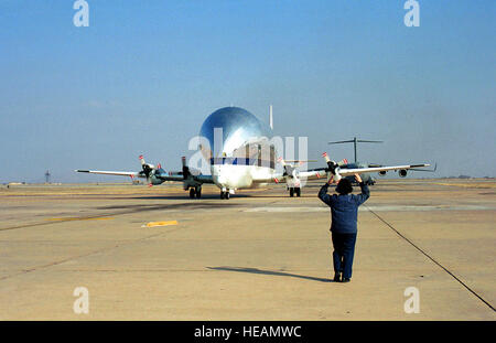 Mittellang erschossen, rechte vordere Ansicht der NASA 377 SGT-F Super Guppy auf Flug Linie bei Altus Air Force Base in Oklahoma, Flughelfer im Vordergrund.  Flugzeuge nicht mehr zum Tanken auf einem Flug von Montgomery, Alabama, Riverside, Kalifornien, ein Stück der Raumstation zu liefern. Stockfoto