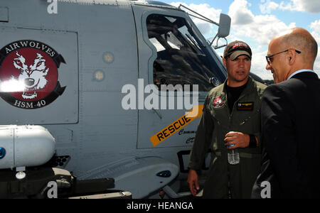 Petty Officer 1st Class Brandon Fullmer, Marine Luft Crewman (taktische), erklärt Merkmale der Marine MH-60R Seahawk ein Zuschauer auf der Farnborough International Air Show 2010 Juli 18. Rund 285.000 Luftfahrt-Enthusiasten besuchen die einwöchige Veranstaltung Hervorhebung Luftfahrt-Antriebstechnik. Stockfoto