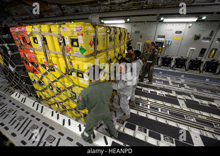 Am 26. April 2015 laden Mitarbeiter der US-Luftwaffe Hilfsgüter auf einen C-17 Globemaster III auf der March Air Force Base, Kalifornien, für die Opfer des Erdbebens in Nepal. Die Mission umfasst USAID Cargo, Personal der Feuerwehr des Los Angeles County sowie Such- und Rettungshunde, um Katastrophenhilfe zu leisten. Stockfoto