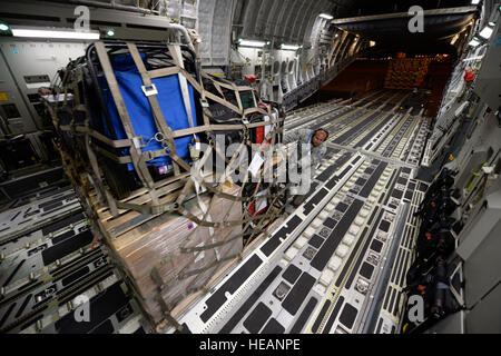 US Air Force Personal laden Hilfsgüter für die Opfer des Erdbebens in Nepal in einem USAF C-17 Globemaster III von gemeinsamen Basis Charleston, SC, im März Air Force Base, Kalifornien, 26. April 2015. Die US Agentur für internationale Entwicklung-Relief-Ladung enthalten acht Paletten, 59 Los Angeles County Fire Department Personal- und fünf Such- und Rettungsmaßnahmen Hunde. Stockfoto