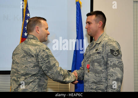 Oberst Richard Williamson, 305th Air Mobility Wing Commander awards Staff Sgt Mark Kosisky, 305th Antenne Port Squadron Air Transport Geselle, den Bronze Star Medal 31. Januar 2013, auf der Passenger Terminal auf gemeinsamer Basis McGuire-Dix-Lakehurst, NJ-Kosisky erhielt die Auszeichnung für seine außergewöhnlichen Verdienste zur Unterstützung der Operation Enduring Freedom und sein herausragendes Engagement in den Dienst während der Kampfhandlungen in Afghanistan wurde ihm der Defense Intelligence Emblem der Ehre vom rumänischen Ministerium für Landesverteidigung und die Bundeswehr Proficiency Abzeichen, Bro Stockfoto