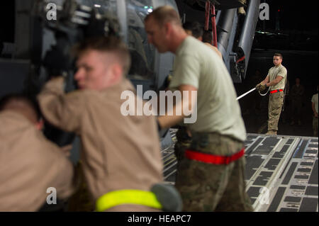 US-Flieger zugewiesen 8. Airlift Squadron und der 41. Expeditionary Rescue Squadron entlasten einen HH - 60G Pave Hawk-Hubschrauber aus einer c-17 Globemaster III Flugzeug in Bagram Air Field, Afghanistan, 27. Mai 2015. US Air Force Frachtflugzeugen haben 19.900 kurze Tonnen Fracht in ganz Afghanistan in diesem Jahr ausgeliefert.  Techn. Sgt Joseph Swafford Stockfoto