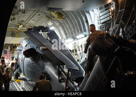 US-Flieger zugewiesen 8. Airlift Squadron und der 41. Expeditionary Rescue Squadron entlasten einen HH - 60G Pave Hawk-Hubschrauber aus einer c-17 Globemaster III Flugzeug in Bagram Air Field, Afghanistan, 27. Mai 2015. US Air Force Frachtflugzeugen haben 19.900 kurze Tonnen Fracht in ganz Afghanistan in diesem Jahr ausgeliefert.  Techn. Sgt Joseph Swafford Stockfoto