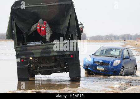 SPC. Jeremy Kasperson sitzt im hinteren Teil ein North Dakota National Guard-LKW wie er Anweisungen gibt für rückwärts aus einer verwaschen Straße 25 März im ländlichen Cass County. Der LKW ist eine gestrandete Automobil von der verwaschen Fahrbahn Abschleppen. Cass County Tactical Operations Center Verbindungsoffiziers Kapitän Grant Larson, der 119. Maintenance Squadron, North Dakota Air National Guard, kann gesehen werden, geben Anleitung vom Fahrerhaus des LKW. Kasperson ist Mitglied der 815th-Ingenieur des Unternehmens North Dakota National Guard schnelle Reaktion Kraft-Team, das in der Szene von der Cass County S aufgerufen wird Stockfoto