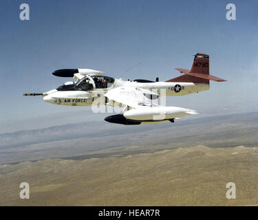 Eine Luft/Luft-linke Seitenansicht eines OA-37 Dragonfly-Flugzeugs mit einer Bombe Markus 20 unter den rechten Flügel und eine Mark 82 500 lb Allzweck Bombe unter dem linken montiert. Stockfoto