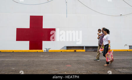 SUBIC BAY, Philippinen (8. August 2015) Joshua Carson, eine Operation Smile Programm-Koordinator, geht mit einer philippinischen Mutter und Kind auf dem Lazarettschiff USNS Mercy (T-AH 19) während der Pazifischen Partnerschaft 2015.  Operation Smile cleft Lip und Patientenauswahl, Logistik und Chirurgie für Kinder mit Gaumenspalte durchgeführt.  Barmherzigkeit ist derzeit in den Philippinen für seine dritte Mission Hafen PP15. Pazifische Partnerschaft ist in seiner zehnten Iteration und ist die größte jährliche multilaterale humanitäre Hilfe und Disaster Preparedness Hilfsmission in der Indo-Asien-Pazifik-Region durchgeführt. Weile Stockfoto