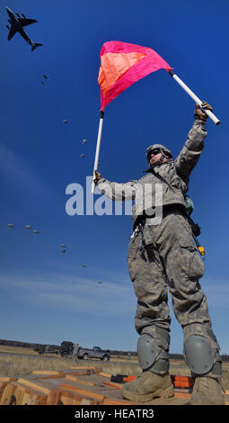 Armee Pvt. Brandon Rawlins, gebürtig in Chesapeake, Virginia, zugewiesen Charlie Batterie, 2. Bataillon, 377. Parachute Field Artillery Regiment, 4th Infantry Brigade Combat Team (Airborne), 25. Infanterie-Division, U.S. Army Alaska, halten ein Rallye-Panel wie Fallschirmjäger einen Fallschirm-Angriff auf Malemute Drop-Zone am gemeinsamen Basis Elmendorf-Richardson, Alaska, Freitag, 20. März 2015, während Betrieb Spartan "Walküre" durchführen. Die Soldaten die Drop-Zone statt und Folgenahrung Ziele und Elemente des 2. Bataillon der Brigade angegriffen, 377. Parachute Field Artillery Regiment feuerte 105 mm Haubitzen. Justin Stockfoto