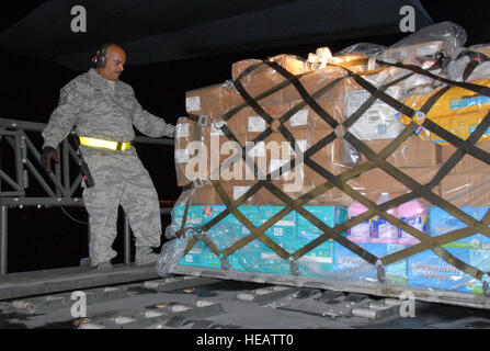 Air National Guard Master Sgt. Wilfredo Roman, schaut Weg Schienen des Laders vor Drücken der Cargo-Paletten mit Grundlagen liefert in der 156AW-Hercules C130-E 25K-NGSL Antenne Porter von der 156. Airlift Wing. Die Hercules C130-E erhält uns SOUTHCOM, 35. Expeditionary Airlift Squadron, wird die Fracht nach Haiti zur Unterstützung der Operation Unified Response transportieren. Stockfoto