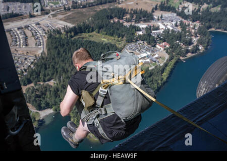 Ein US-Soldat, die Charlie Kompanie, 52. Infanterie-Regiment zugewiesen führt einen static-Line-Fallschirmsprung aus einem UH - 60M Black Hawk Hubschrauber, 16. Combat Aviation Brigade, 7. Infanterie-Division, am Joint Base Lewis-McChord, Wash., 17. August 2016 zugewiesen. Die Soldaten abgeschlossen einen Sprung ins amerikanische See um Kampfbereitschaft zu erhöhen. Stockfoto