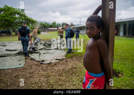 ARAWA, autonome Region von Bougainville, Papua New Guinea (3. Juli 2015) ein Junge als Soldat innen Uhren brechen ein Zelt am Ende einer Gemeinschaft Gesundheit Engagement in der Arawa medizinische Klinik. Medizinisches Personal aus dem Lazarettschiff USNS Mercy (T-AH 19) wurden in der Klinik, medizinische Dienstleistungen und Informationen zur Gesundheit Sensibilisierung Bewohner bieten. Barmherzigkeit ist derzeit in Papua-Neu-Guinea für seine zweite Mission Hafen PP15. Pazifische Partnerschaft ist in seiner 10. Iteration und ist die größte jährliche multilaterale humanitäre Hilfe und Disaster Preparedness Hilfsmission durchgeführt Stockfoto