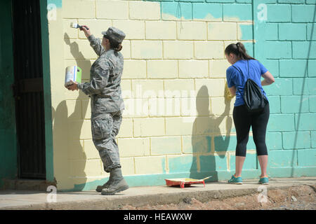 US Air Force Tech SGT Jasmine Matus (links), 35. Bekämpfung Kommunikation Geschwader Radiofrequenz Getriebe Handwerker aus Tinker Air Force Base in Oklahoma, und US Air Force Senior Airman Ashley Cooke, 823. Expeditionary RED HORSE Squadron Dienstleistungen Spezialist aus Hurlburt Field, Florida, Malen eines bestehenden Schulhäuser auf der Baustelle Gabriela Mistral Schule 15. Juli 2015. Der Schulstandort ist ein Teil der neuen Horizonte Honduras 2015 Training Übung durch Trujillo, Honduras.  New Horizons wurde in den 1980er Jahren ins Leben gerufen und ist eine jährliche gemeinsame humanitäre Stockfoto