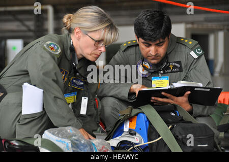 Asif Jah, Pakistan Luftwaffe Fliegerarzt, inspiziert Pre-Flight Gear mit einem Mitglied des Team McChord Aeromedical Evakuierung Teams während des Juli 27 AE-Wettbewerbs. Flieger, die 1. Klasse Michael Schlachten) Stockfoto