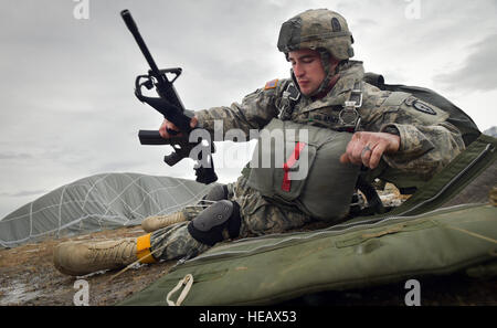 Armee-Personal-Sergeant Mark Conner, ein Eingeborener von Blue Ridge, Ga., zugeordnet der 4th Infantry Brigade Combat Team (Airborne), 25. Infanterie-Division, U.S. Army Alaska, legt seine Waffe in Malemute Drop-Zone am gemeinsamen Basis Elmendorf-Richardson, Alaska, Mittwoch, 18. März 2015, als Teil eines größeren taktischen Bereich Übung in Betrieb Momente nach der Landung bei einem Angriff der Praxis gezwungen Eintrag Fallschirm. Die Soldaten sind Bestandteil der Armee nur Pacific Luftlandebrigade mit der Fähigkeit, sich schnell weltweit bereitstellen und sind darauf trainiert, militärische Operationen unter strengen Bedingungen durchzuführen. Justin Connaher) Stockfoto