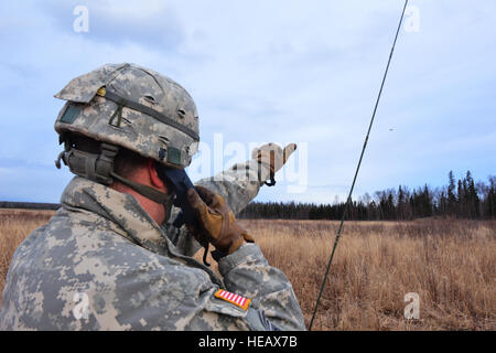 Sgt. 1. Klasse John Bailey, 2nd Battalion, 377. Parachute Field Artillery Regiment Chef Feuerleitung Unteroffizier und Akron, Ohio, native Punkte für eine eingehende CH-47F Chinook-Hubschrauber, beladen mit Fallschirmjägern bereit zu springen. Als eine Armee-Pfadfinder signalisiert Bailey den Heli im hinteren Teil des Flugzeugs der geeignete Zeitpunkt für die Fallschirmjäger springen. (US Air Force Photo/Flieger 1. Klasse Kyle Johnson) Stockfoto