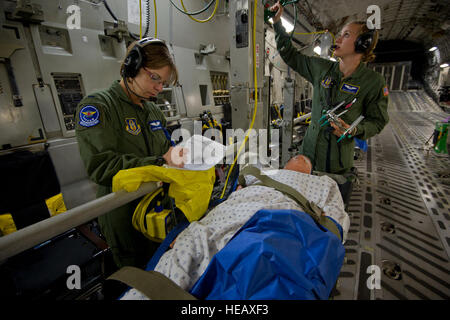 US Air Force 1st Lt. Diane Marshall, ein Flug-Krankenschwester mit 932nd Aeromedical Evakuierung-Geschwader, Scott Air Force Base, Illinois, und Senior Airman Hannah Rice, einer fliegerärztlichen Techniker mit der 94. Aeromedical Evakuierung-Geschwader, Dobbins Air Reserve Base, Georgia, überprüfen Sie den Status einer simulierten Unfall bei einem Übungsflug aeromedical Evakuierung, 7. Mai 2014, am Fort McCoy, Wisconsin, USA zur Unterstützung der Übung Patriot Krieger 2014. Vereinigte Staaten militärische Reserve Komponenten aus allen Branchen beteiligen kombiniert Übungen Patriot Krieger, Global Medic, Diamond Saber und CSTX in Vorbereitung fo Stockfoto