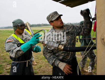 US Army Spc. Hector Bermudez und Pfc William Colon, Erdöl Versorgung Spezialisten aus dem 941st Viertel-Master-Unternehmen, Salinas, Puerto Rico, aufrollen Kraftstoffschlauch in ein schwerer erweiterter Mobilität taktischer LKW am 8. Mai 2014, zur Unterstützung der Bewegung Patriot Krieger am Fort McCoy, Wisconsin, USA Vereinigte Staaten militärische Reserve an Komponenten aus allen Branchen kombinierte Übungen Patriot Krieger , Global Medic, Diamond Saber und CSTX in Vorbereitung auf bevorstehende Einsätze in gemischten Umgebungen. Staff Sgt Joseph Araiza Stockfoto