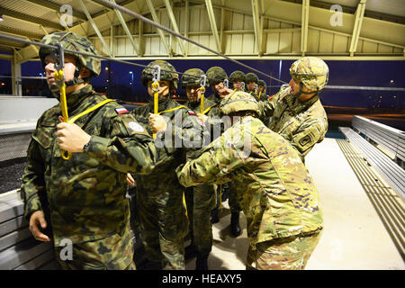 US Army Jumpmasters, 173rd Airborne Brigade zugewiesen überprüfen Sie richtige Körperposition des polnischen Fallschirmjäger aus der 6. Airborne Brigade auf Aviano Air Base mock Tür Training in Vorbereitung auf airborne Operations bei Juliet Drop-Zone in Pordenone, Italien, 17. Oktober 2016, als Teil der Peacemaster Einheit Training. Peacemaster Einheit ist Joint multinational Readiness Übung mit Beteiligung aus 7 Nationen, die Durchführung von Missionen in 3 Ländern liefert mehr als 2000 Soldaten und 20 schweren Tropfen. Der 173rd Airborne Brigade ist der US-Armee Kontingenz Response Force in Europa, in der Lage Stockfoto