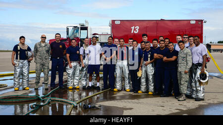 Feuerwehrleute aus der 612th Air Base Squadron und El Salvador versammeln nach El Salvador autonomen Hafen Kommission Flughafen Feuerwehrmann live-Feuer auf Soto Cano Air Base, Honduras, 3. Dezember 2014. Der 612th ABS-Feuerwehr erleichtert El Salvadors autonomen Hafen Kommission Flughafen Feuerwehrmann Qualifikation durch die Bereitstellung von live-Feuer. Die El Salvador Flughafen-Feuerwehr haben eine Anforderung sehr ähnlich zu den Standards der Vereinigten Staaten, die Mitglieder der ihre Flughafen-Feuerwehren qualifiziert jährlich auf ihre Fähigkeit, eine live-Feuer zu kontrollieren sein. Techn. Sgt Heathe Stockfoto