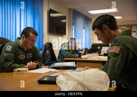 Gehen Sie ersten Lt. Robert Stephenson und Captain Kenneth Jubb, 37th Airlift Squadron Piloten über Missionsplanung 22. Januar 2015, auf der Ramstein Air Base, Deutschland. Die Absicht der Mission war, die Piloten fliegen auf 7000 Fuß sowie eine simulierte Fracht Drop Kenntnisse weiterhin zu trainieren. Senior Airman Jonathan Stefanko) Stockfoto