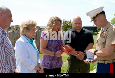 Captain Byron Owen, United States Marine Corps, präsentiert der Navy und Marine Corps Commendation Medal mit Kampf gegen Unterscheidung Gerät postum für Familienangehörige von 1st Lt. Trevor J. Yurista. Die Preisverleihung wurde von Marine Air Gruppe 49, Abteilung B, gehostet auf Stewart Air National Guard Base, N.Y. Yurista, ein Mitglied der 5. Marine Regiment stationiert, 1. Marineabteilung, ich Marine Expeditionary Force, diente mit Force Recon Platoon, Task Force 2/7, als er eine tödliche Verwundung von einem improvisierten Sprengsatz nahm während der Rückkehr von Aktionen er gegen die Aufständischen in Afghanistan koordinierte Stockfoto