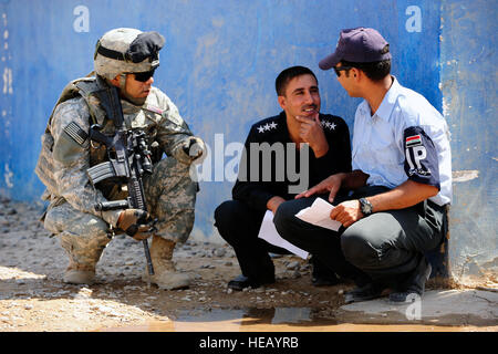 US Armee Sgt. 1. Klasse Ernesto Soriano aus der 25. spezielle Truppen Bataillon Sicherheitsabteilung, 25. Infanteriedivision spricht mit irakischen Polizisten während der sensiblen Seite Ausbeutung Ausbildung durchgeführt am Sequor Polizeistation in der Nähe von Tikrit, Irak, 9. September. Stockfoto