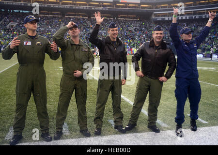 Petty Officer 2. Klasse Andrew Johnston, Petty Officer 2. Klasse Bryan McCarthy, Lt. Jared Hylander, Lt. Jake Marks und Lt. CMdR Matt Calvert, MH-65 Dolphin Helikopter Besatzungsmitglieder von Coast Guard Air Station Port Angeles, Washington, Rallye Seahawks Fans vom Feld CenturyLink in Seattle während eines Spiels Seattle Seahawks 27. Dezember 2015. Die Mannschaften haben eine Überführung in zwei Dolphin Helikopter vor dem Spiel während des Singens der Nationalhymne während die Mitglieder von der Coast Guard und andere militärische Niederlassungen präsentiert die amerikanische Flagge auf dem Feld. (US Coast Guard Seemann Sarah Wilson) Stockfoto