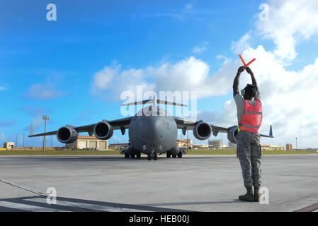 Flieger 1. Klasse David Reed, 734th Air Mobility Squadron Crewchief, Marschälle eine c-17 Globemaster III, 18. April 2015, auf der Flightline auf Andersen Air Force Base, Guam. Flieger aus dem 36. Flügel und die 734th AMS Arbeit Projekt global zu erreichen und ermöglichen Militärführer, Airpower über das gesamte Spektrum des Engagements zu beschäftigen.  Senior Airman Katrina M. Brisbin Stockfoto